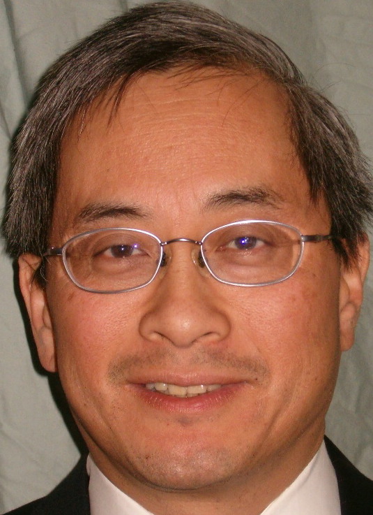 Head shot of Richard Hom, OD, MPH. He is facing forward, wearing glasses, and smiling