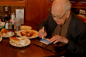 A man signing credit card slip with signature guide