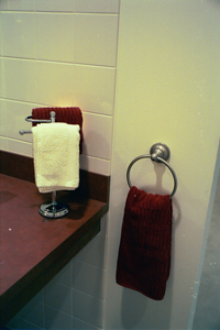 burgundy towels hung in white bathroom