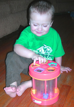 Eddie playing with a shape sorting toy