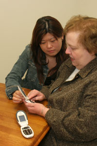 Two women inspecting a cell phone.