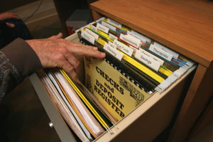 a file drawer opened to reveal files and a large-print check register