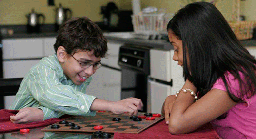 Low vision boy and girl playing checkers